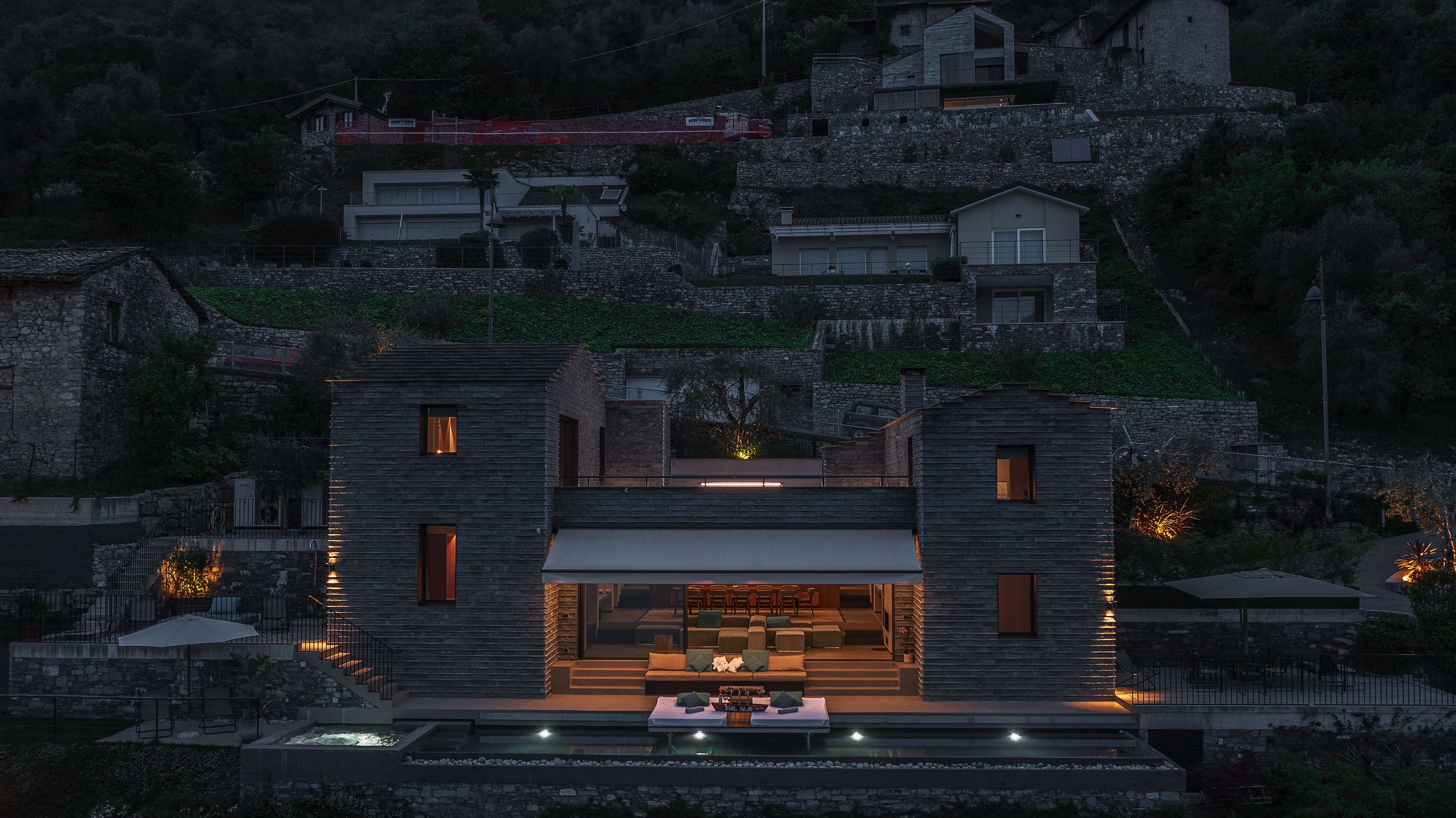 Modern stone villa with infinity pool at night