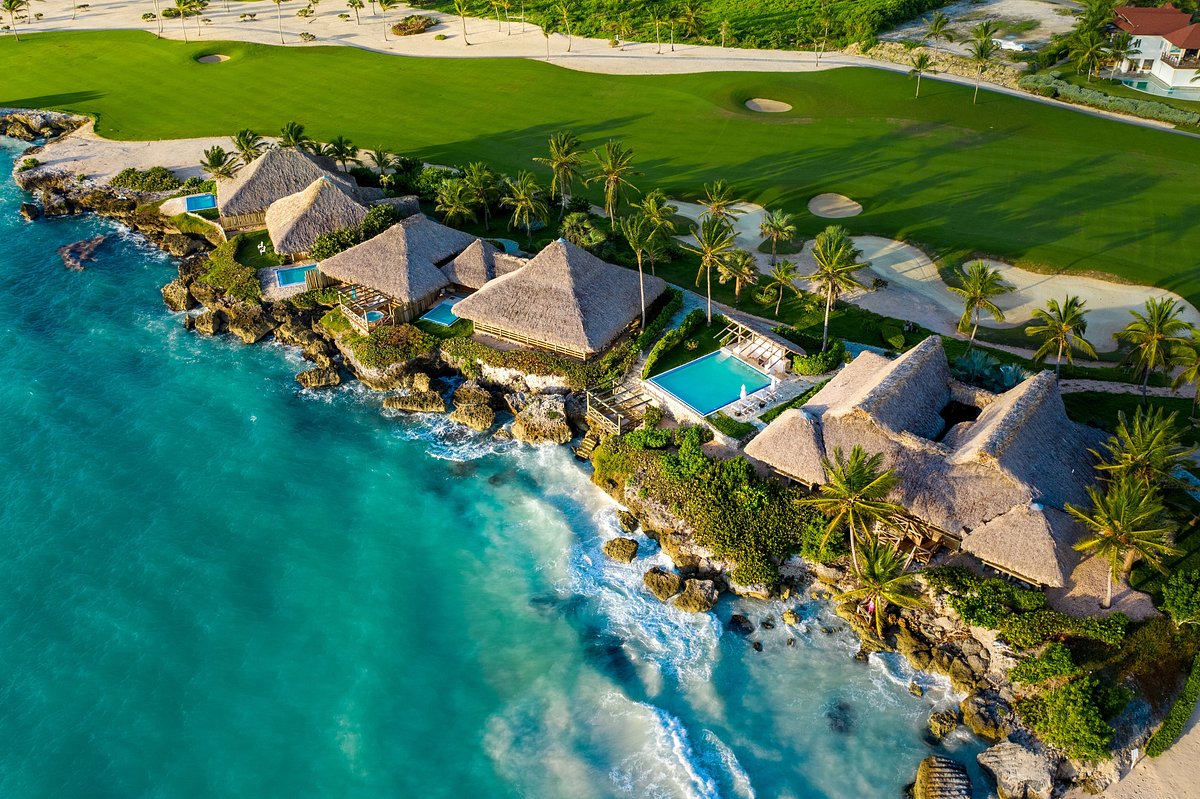 Eden Roc oceanfront bungalows with thatched roofs perched on rocks above turquoise ocean